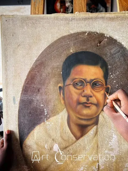 Here you can see my careful restoration process in action. I am meticulously retouching a portrait, using a reference photograph on my phone to ensure complete accuracy to the original artist's style.