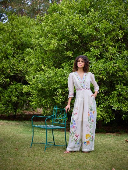 The same look styled with a simple garden chair as a prop. This adds a touch of narrative and context to the image, making it feel like a quiet moment in a beautiful garden.