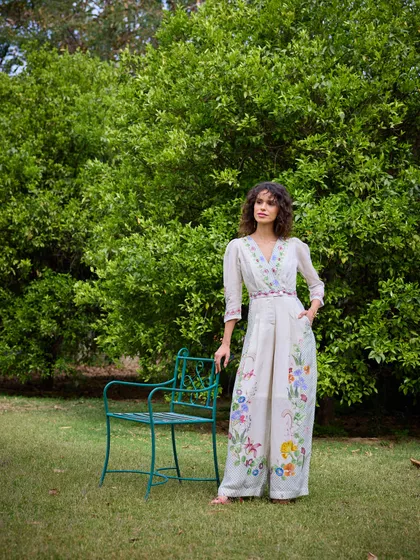 The same look styled with a simple garden chair as a prop. This adds a touch of narrative and context to the image, making it feel like a quiet moment in a beautiful garden.