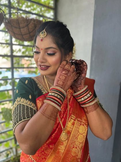 A close-up of this beautiful baby shower look. The makeup is soft and shimmery, with a bold lip that adds a touch of celebration to her traditional attire.