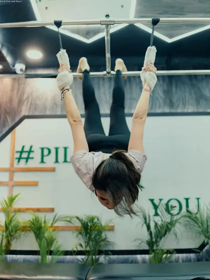 This inverted pose on the Cadillac requires a high level of core control and upper body strength. It's a challenging move that we build up to with consistent training.