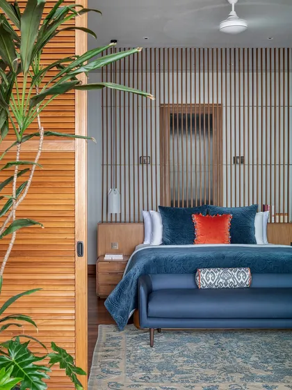 The master bedroom is defined by a wooden screen and console that create a passage to the walk-in wardrobe and bathroom. This element also anchors the bed, which is oriented to take in the sweeping views of the Arabian Sea.