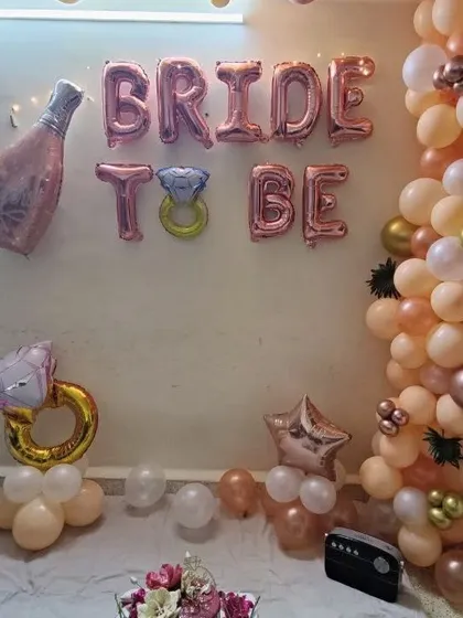 Even small home functions can be special. This is a 'Bride to be' party setup we did, featuring a stylish rose gold balloon garland and fun foil balloons to create a festive corner for the celebration.