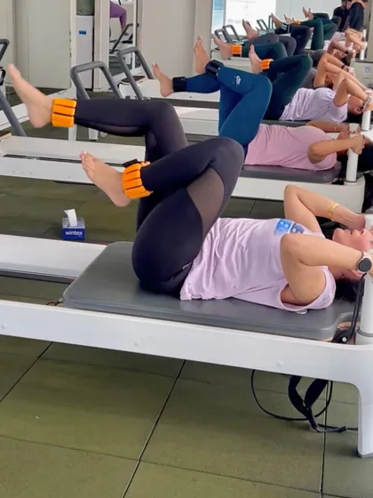 The energy in our group classes is unmatched. Here, our clients work in sync on the reformer, performing tabletop crunches with ankle weights to intensify the core workout and build lower abdominal strength.