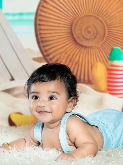 This little one is looking curious and happy on the beach.
