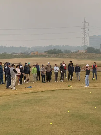 A wide shot of our Short Game Masterclass, showing a group of players learning together on the practice green.