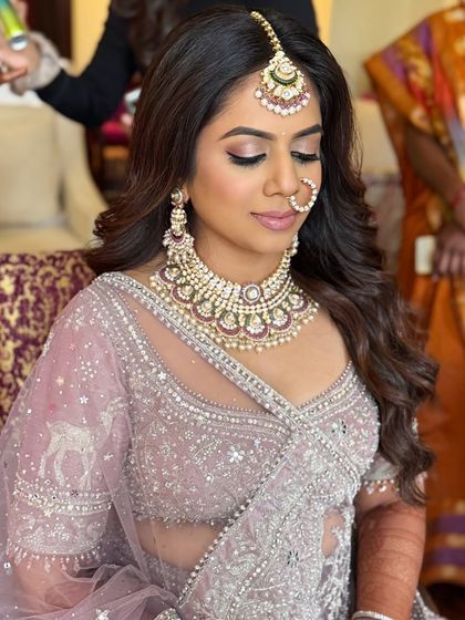 This image showcases the soft smokey eye and voluminous hair that pairs beautifully with a pastel wedding lehenga.