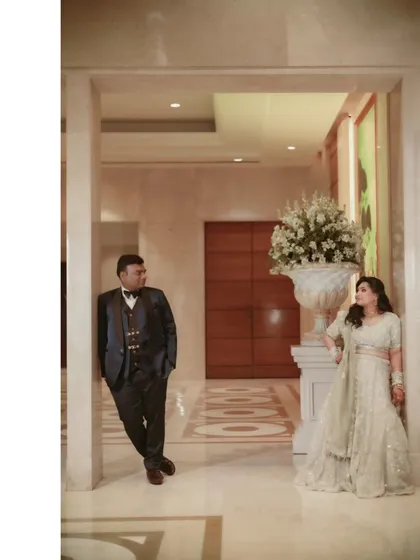 A stylish, posed shot of the couple in a grand hallway, their distance creating a sense of anticipation and modern elegance.