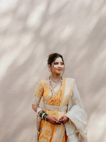 A beautiful three-quarter profile of the bride, showcasing her elegant hairstyle and the soft glow of her makeup.