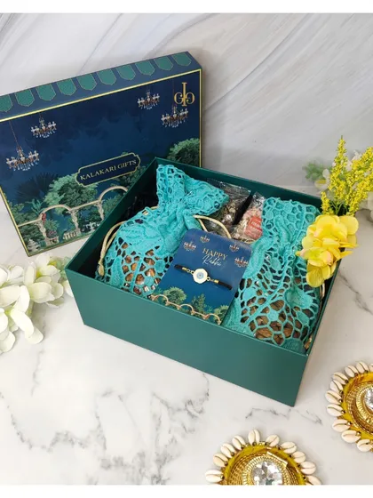 A beautiful teal-themed Rakhi hamper, featuring lace potlis and shell diyas in an elegant gift box.