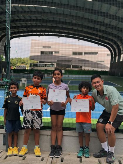 A group of our junior players proudly holding their achievement certificates with their coach. These events are a great way for kids to experience competitive play in a supportive setting.