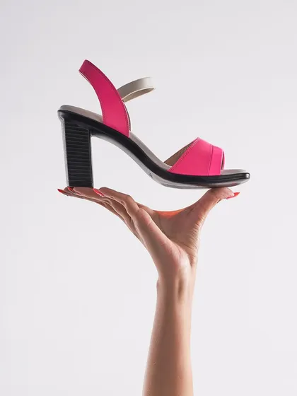 A simple, elegant, and effective concept. This shot for Pepitoes Footwear uses a hand to present the sandal as if it were a precious object, drawing all attention to its design and vibrant pink color.