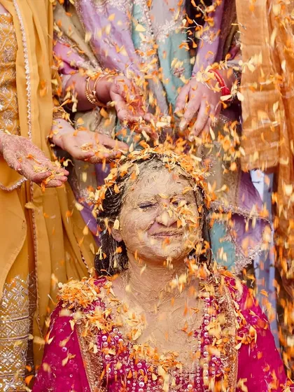 The pure, unscripted joy of a Haldi ceremony. This is one of my favorite moments to capture, with family showering the bride in turmeric and flower petals, creating vibrant and emotional photographs.