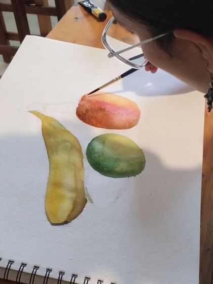 A still from a recent session, showing a student painting a still life of fruits. These exercises are crucial for building foundational skills in watercolor.