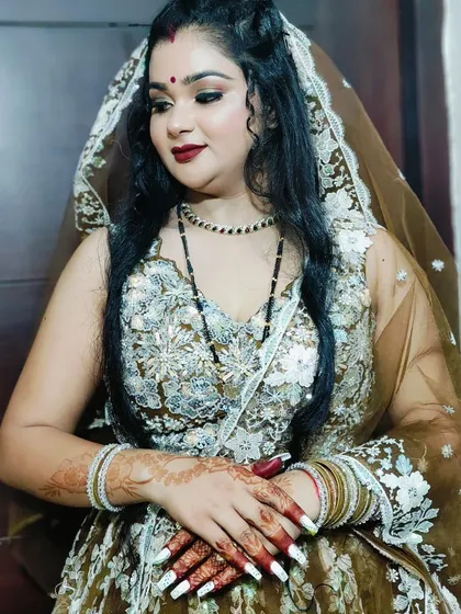 A portrait of the client in her brown floral lehenga, her hands gracefully crossed.