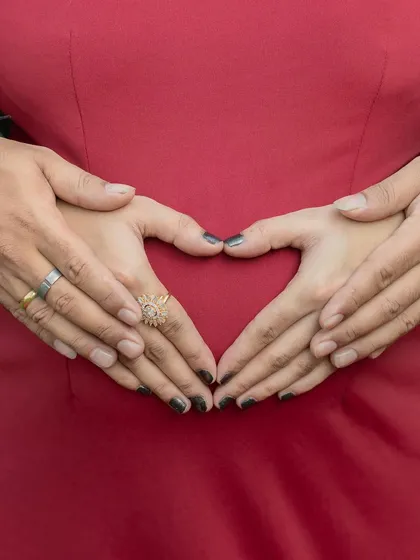 Both partners' hands forming a heart on the baby bump. This is a classic and meaningful pose that symbolizes your shared love for your growing baby.