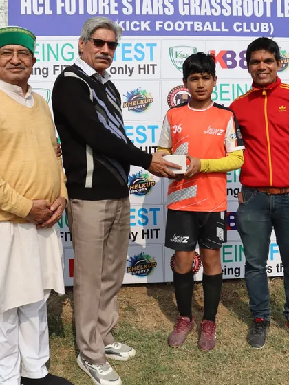 A young player receives an award for his performance in the HCL Future Stars Grassroots League, recognized for his hard work and skill.