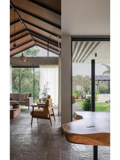 A wide view of the living and dining areas in Grove House. The open-plan layout, high ceilings, and large glass openings create a spacious and airy environment that is perfect for large family gatherings and entertaining friends.