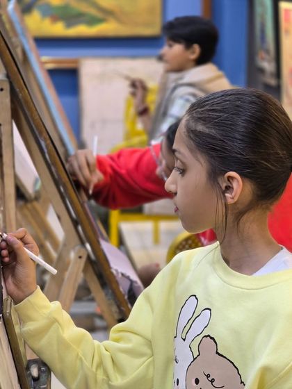 A young artist concentrates on her drawing. We teach students of all ages, and it's wonderful to see them develop their skills and passion for art.