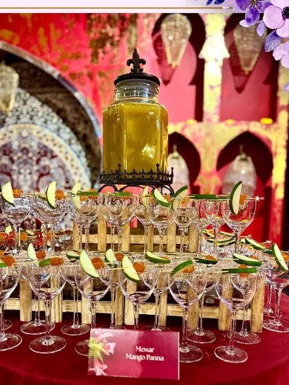 A pyramid of glasses ready for our Mewar Mango Panna mocktail, a refreshing choice for a large wedding.