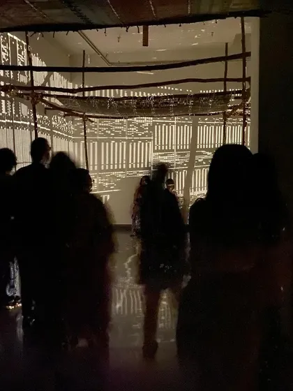 The students silhouetted against the glowing walls of the installation.
