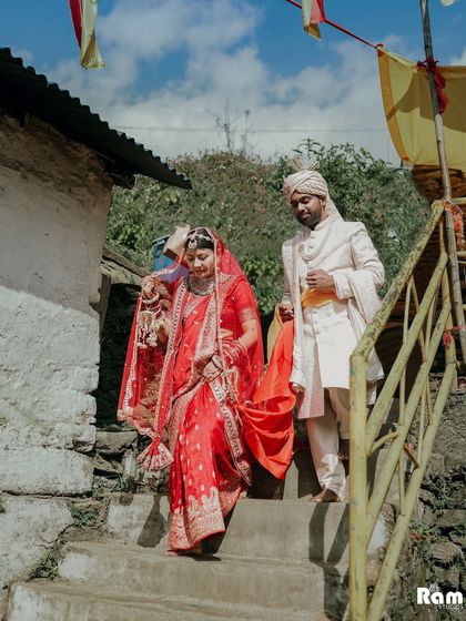 A unique shot from a destination wedding at the Triyuginarayan Temple in the Himalayas. The couple is seen descending stone steps after their ceremony, capturing the rustic and spiritual essence of their wedding location.