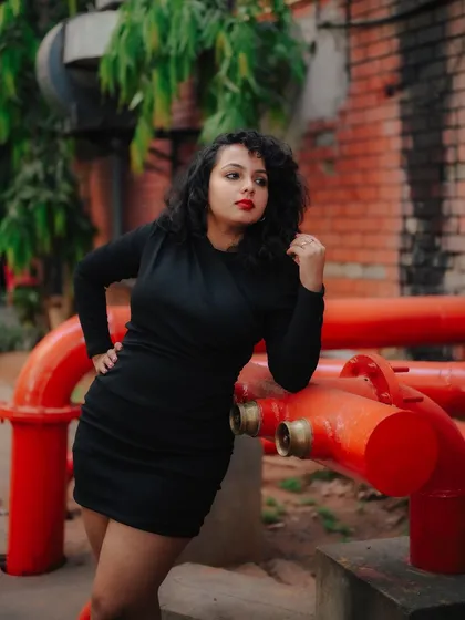 A duplicate of image 446, this portrait uses the contrast of a black dress against red pipes for a striking industrial fashion shot.