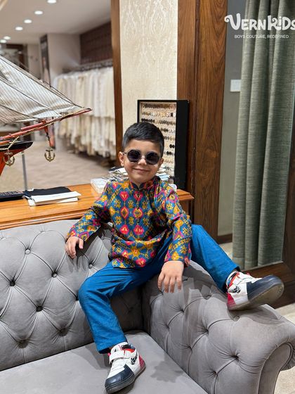 This little dude is rocking his printed kurta and sunglasses. It's a look that's full of personality and perfect for any fun occasion.