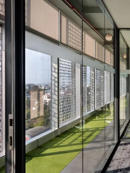 A meeting room with a view of an outdoor green terrace. The use of glass walls and proximity to nature creates a refreshing and inspiring environment for collaboration.