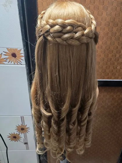 Another look at the braided crown hairstyle, focusing on the texture and finish. This style is perfect for anyone wanting a neat hairstyle that keeps hair away from the face while still looking glamorous.