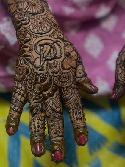 A close up of the initials 'P' and 'D' in this engagement mehndi. Personalizing the design makes it a cherished part of the memory.