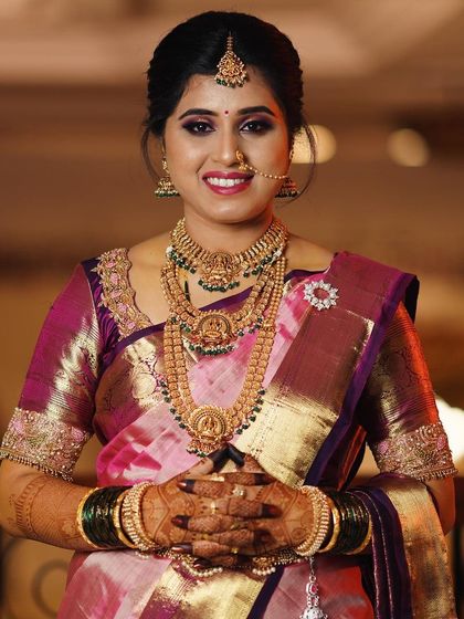 A beautiful portrait of the bride, her hands joined in a traditional pose, showcasing her henna.