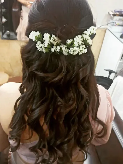 My bridal packages include professional hairstyling. Here, my hairstylist created a lovely half-up style with soft curls, adorned with fresh baby's breath for a romantic and delicate touch.