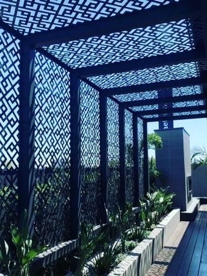 This intricate laser-cut metal pergola is a work of art. It provides shade while casting beautiful geometric shadows, demonstrating how we can incorporate unique, decorative elements into our structural designs.