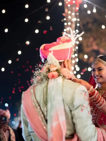 The 'varmala' exchange under a sky of string lights, creating a magical atmosphere for this important ritual.
