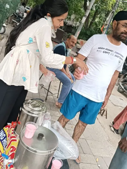 Serving the community includes people from all walks of life. Here, a volunteer offers a cool drink to a gentleman, embodying the spirit of respect and care that defines *Sachi Sewa*.