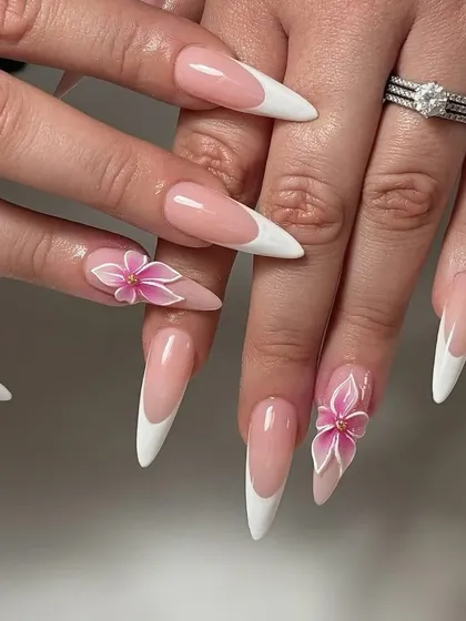 Combining two styles I love. This look features extra-long stiletto nail extensions with a classic French tip, elevated by beautifully sculpted 3D pink flowers on the accent nails.