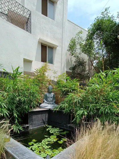 This is another angle of the granite pond with a Buddha statue, surrounded by lush bamboo. The water lilies add a touch of natural beauty to the modern design.