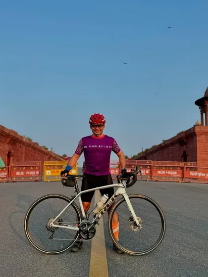 A rider posing with his white Trek bike.