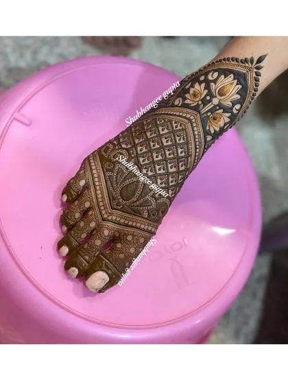 A very popular style for bridal feet, this design features a thick band of lotus flowers at the ankle and intricate geometric patterns covering the top of the foot. The contrast makes the design stand out.