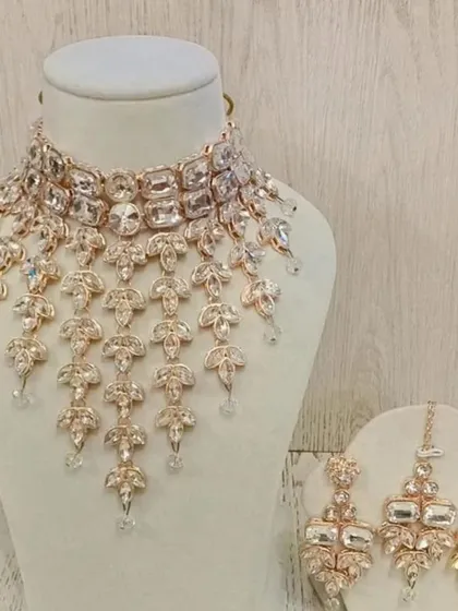 Make a statement with this modern American Diamond necklace set. The cascading design is perfect for a cocktail gown or a contemporary lehenga.