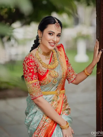 A classic pose by the doorway, showcasing the elegant drape of her saree and the flawless makeup.