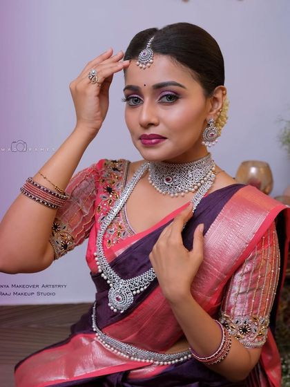 A model showcasing a beautiful silver-finish jewellery set with pearl accents. The choker and long necklace create a look of modern royalty.