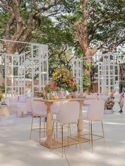 A high-top bar table and chairs offer a different kind of seating option at the "Bloom" wedding, perfect for mingling.