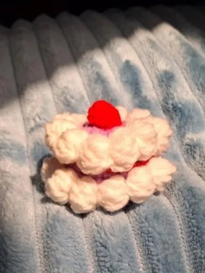 A tiny crochet cake keyring, perfect for celebrating a birthday.
