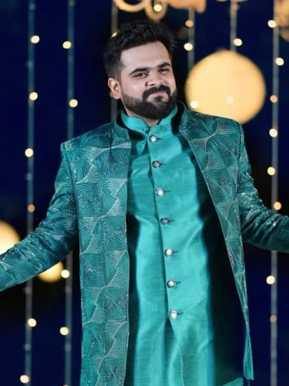 Client Rishabh owning the night at his sangeet. He is wearing a custom teal Indo-Western jacket with a geometric pattern, designed to make a statement.