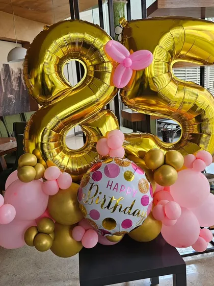 A cheerful 25th birthday balloon bouquet in gold and pink. This is a great example of a smaller decor element that can make a big impact in any space.