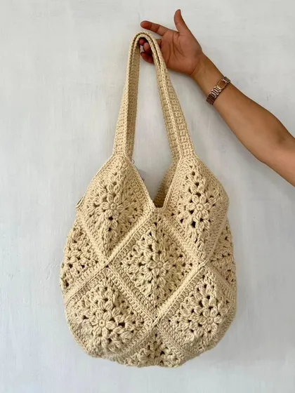 This is one of my classic crochet tote bags, made in a single, neutral cream color. The design is built from traditional granny squares, creating a beautiful, textured pattern. It's a spacious and durable bag, perfect for everyday use.