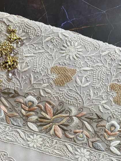 A sophisticated grey georgette suit, featuring intricate Chikankari highlighted with multi-tonal embellishments and beadwork.