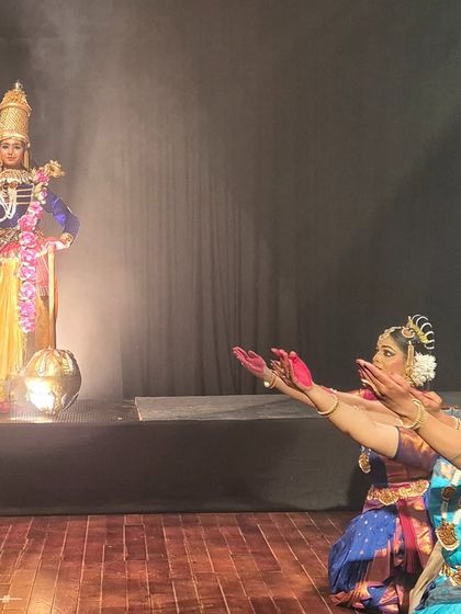 A powerful stage moment showing dancers paying reverence to Lord Vishnu. The composition and dramatic lighting create a sense of awe and devotion.